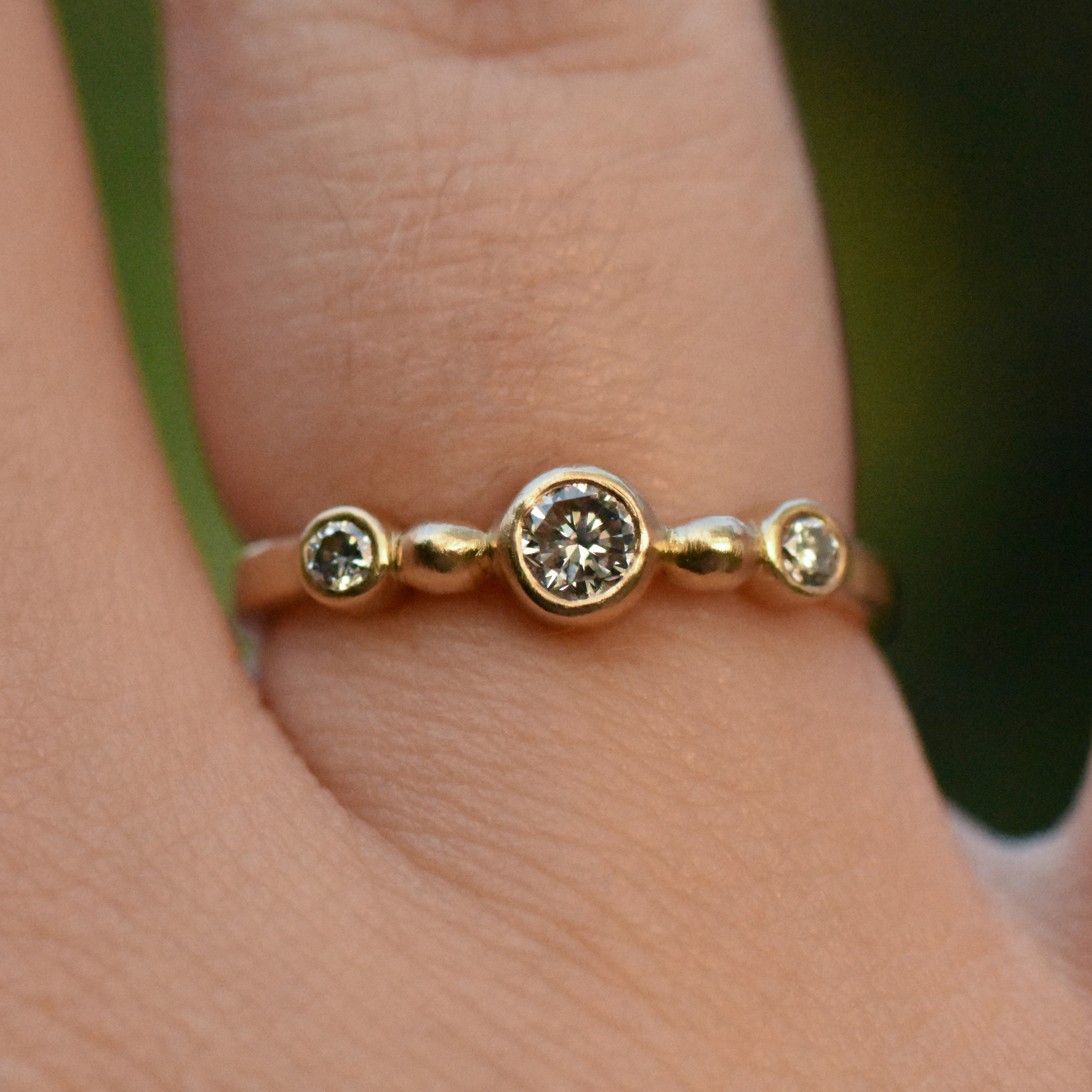 A photo of a 14k gold diamond ring on a finger