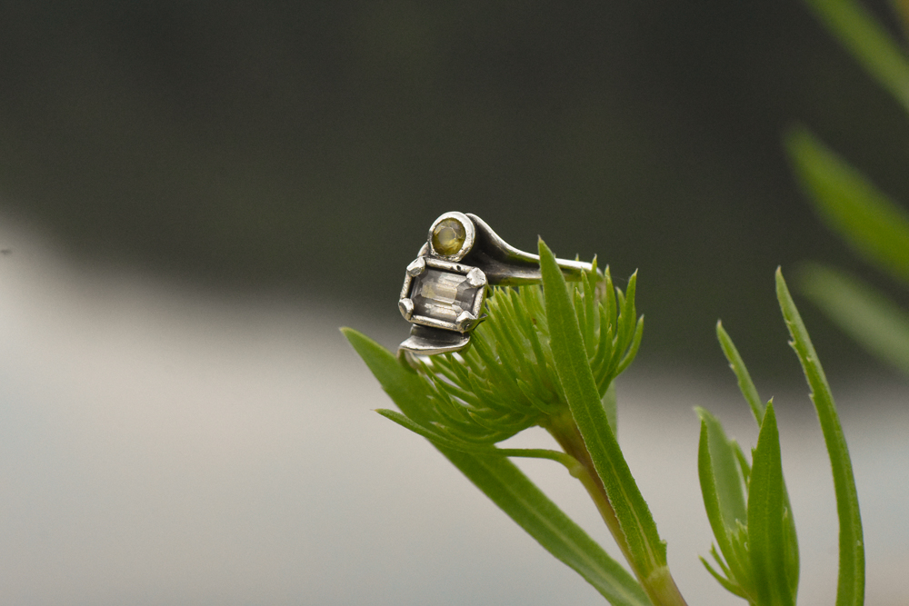 A photo of a sterling silver ring with alexandrite and demantoid garnet